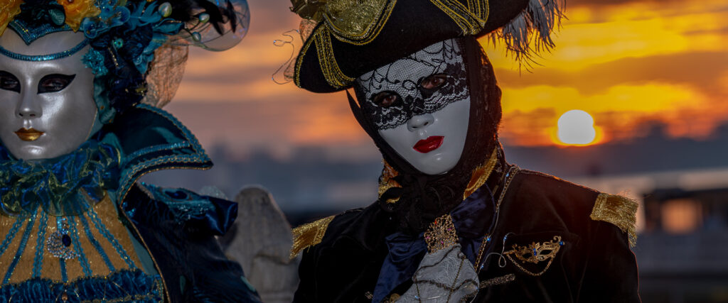 Masques du Carnaval de Venise devant un coucher de soleil à Venise